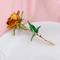 Dettaglio ravvicinato che mostra la trama metallica di una spilla a rosa dorata - Giallo