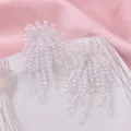 Elegante lange weiße Perlenohrringe mit Quasten für Damen auf rosa Hintergrunddekor - Ohrstecker