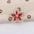Gros plan d'une élégante broche fleur à comics pétales avec cristaux rouges et brillants - Rouge