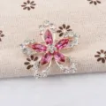 Detailweergave van een elegante roze kristallen bloemspeld met fonkelende steentjes - Magenta