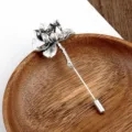 Primer plano de un broche de flor de loto plateado vintage en un cuenco de madera - Loto Plata Antiguo