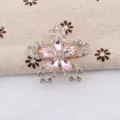 Detailweergave van een bloembroche met roze kristallen blaadjes en witte strassteentjes - Roze