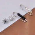 Primer plano detallado de juego de broches de perlas y elegantes pendientes forma de sol - Cuatro Piezas con Adornos (9# Juego)
