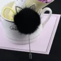 Nahaufnahme einer schwarzen Nerzfell-Brosche mit funkelnden Strass-Katzenohren - Schwarz