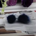 Detaillierte Nahaufnahme der Textur von zwei navyblauen Nerzfell-Pompon-Ohrringen - Dunkelblau