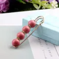 Detail einer eleganten goldene Sicherheitsnadel-Brosche mit rosa Perlen und Kristallen - Rosa