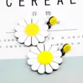 Detailansicht großer weißer Gänseblümchen-Ohrstecker mit gelber Mitte auf Buch - Gänseblümchen-Stil / Gelbe Blume