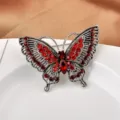 Primer plano de elegante broche de mariposa con cristaux rojos y detalles de metal plateado - Tipo 01 Rojo