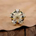 Detailansicht einer goldfarbenen Brosche in Form einer Blume mit klaren Zirkonias. - Gold