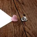 Detailansicht einer rosa herzförmigen Katzenaugenstein-Brosche mit Silberverschluss. - Herz / 1.2cm / Rosa