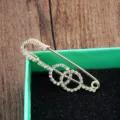 Eleganter goldener Sicherheitsnadel-Brosche mit funkelnden verschlungenen Strass-Ringen - Doppelschleifen-Stil / Spaltring