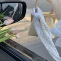 Vista dettagliata di una sciarpa floreale legata al manico di una borsa di paglia per l'estate. - Fascia per Capelli Stampata / Fiori blu