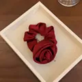 Elegantes weinrotes Satin-Haargummi mit einem 3D-Rosenblütendesign für schickes Styling - Rot