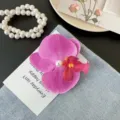 Elegant purple orchid flower hair claw clip with pearl accent on denim fabric backdrop - Dark Purple Side Clip