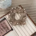 Vintage braunes Organza-Haargummi mit weißen Perlenakzenten für elegantes Haarstyling. - Camel