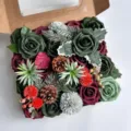 Vue détaillée d'une boîte cadeau DIY de fleurs artificielles de Noël avec roses et pommes. - Multicolore