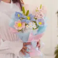 Vista detallada de un ramo de flores hecho a mano con limpiapipas en papel de regalo azul y rosa. - NNSP019
