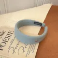 Diadema ancha de lana azul claro con pequeño distintivo dorado oval - Azul