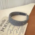 Diadema ancha de lana gris elegante para otoño e invierno con un detalle dorado. - Gris