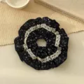 Elegant black floral scrunchie with white lace trim on a cream woven mat background - Lace Floral Patchwork Style / Navy Blue