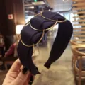 Elegant navy blue wide fabric headband featuring decorative interlocking golden metal rings. - Navy Blue