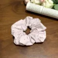 Rosa gepunkteter Haargummi auf Holzgrund mit weißen Rosen - Stoffhaargummi mit Punktmuster / Cremefarbenes Rosa