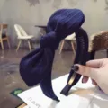 Solid navy blue striped knit headband featuring a stylish large rabbit ear bow tie - Sapphire Blue