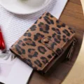 Portafoglio corto da donna con stampa leopardata, scomparti per carte e tasca portamonete. - Marrone