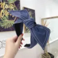 Elegante diadema de mezclilla azul con un lazo grande y detalles de costura blanca - Azul