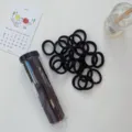 Seamless black elastic hair ties set displayed with a clear portable storage tube container - 20 Piece Set / Black Series