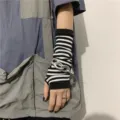 Detail of Y2K striped fingerless arm warmer with chunky silver chain wrist accessory. - Black and White