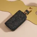 Astuccio per chiavi auto in pelle glitterata nera con zip dorata e gancio metallico quotidiano. - nero e oro
