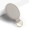Llavero de cuero PU ovalado gris con anillo de metal dorado, diseño minimalista elegante. - Y-04 Gris