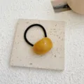 Minimalist yellow acrylic jelly bean hair tie featuring a black elastic band for women - Yellow