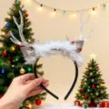 Primer plano de una diadema navideña luminosa con plumas blancas y astas de reno claras. - Diadema con Velo de Cuernos de Reno - Papá Noel (2#) / Blanco