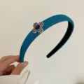 Elegant blue padded headband with rhinestone snowflake ornament for high-volume hair look - Peacock Blue Clover