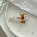 Barrette à cheveux en cristal avec nœud marron et strass sur un plateau en céramique blanc - Pince Nœud Jaune Gingembre Strass