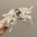 Detailed macro shot showing textures of elegant ostrich feather hair claw clip in beige - L / Beige