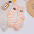 Cozy orange and white striped coral fleece socks for winter warmth and home comfort. - Orange and White Striped