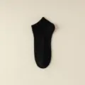 High-quality men's solid black low-cut ankle socks with a classic ribbed knit texture - One Size / Black