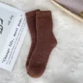 Detailed texture of brown coral fleece fuzzy sleeping socks on a soft white rug - Sizes 39-44 / Coffee
