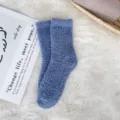 Close-up of cozy blue coral fleece fuzzy socks on white soft faux fur background - Sizes 39-44 / Denim Blue