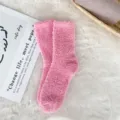 Detailed view of soft pink coral fleece fuzzy socks displayed on a white fluffy rug - Sizes 39-44 / Pink