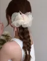 Grand chouchou en organza blanc orné de nœuds en ruban rose sur une coiffure tressée - Style Noeud en Résille / Blanc Cassé