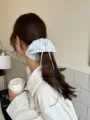 Blue striped lace scrunchie with white bow detail worn by a model in a cafe setting - Large Flare Bow Style / Sea Salt Blue Striped