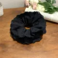 Detailed shot of large black lace scrunchie with intricate floral eyelet edges - Black Without Ribbon