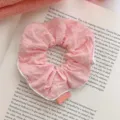 Soft pink textured polka dot fabric scrunchie hair tie with a decorative PINK tag label - Pink Polka Dot