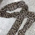 Detail view of a lightweight leopard print silk scarf laid on a grey stone surface. - Leopard Print Style (ED6000464) / Brown