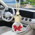 Detailansicht der Autoparfumflasche, hängender Aromadiffusor mit rotem Schmetterling und Holzdeckel. - Rot