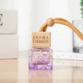 Detailaufnahme der lila Wasserwuerfel Auto Parfuemflasche mit Holzdeckel und Haengeseil. - Lila